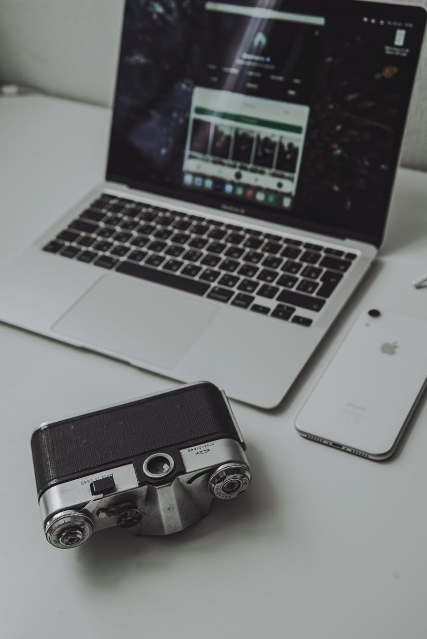 analog camera laptop and phone on desk