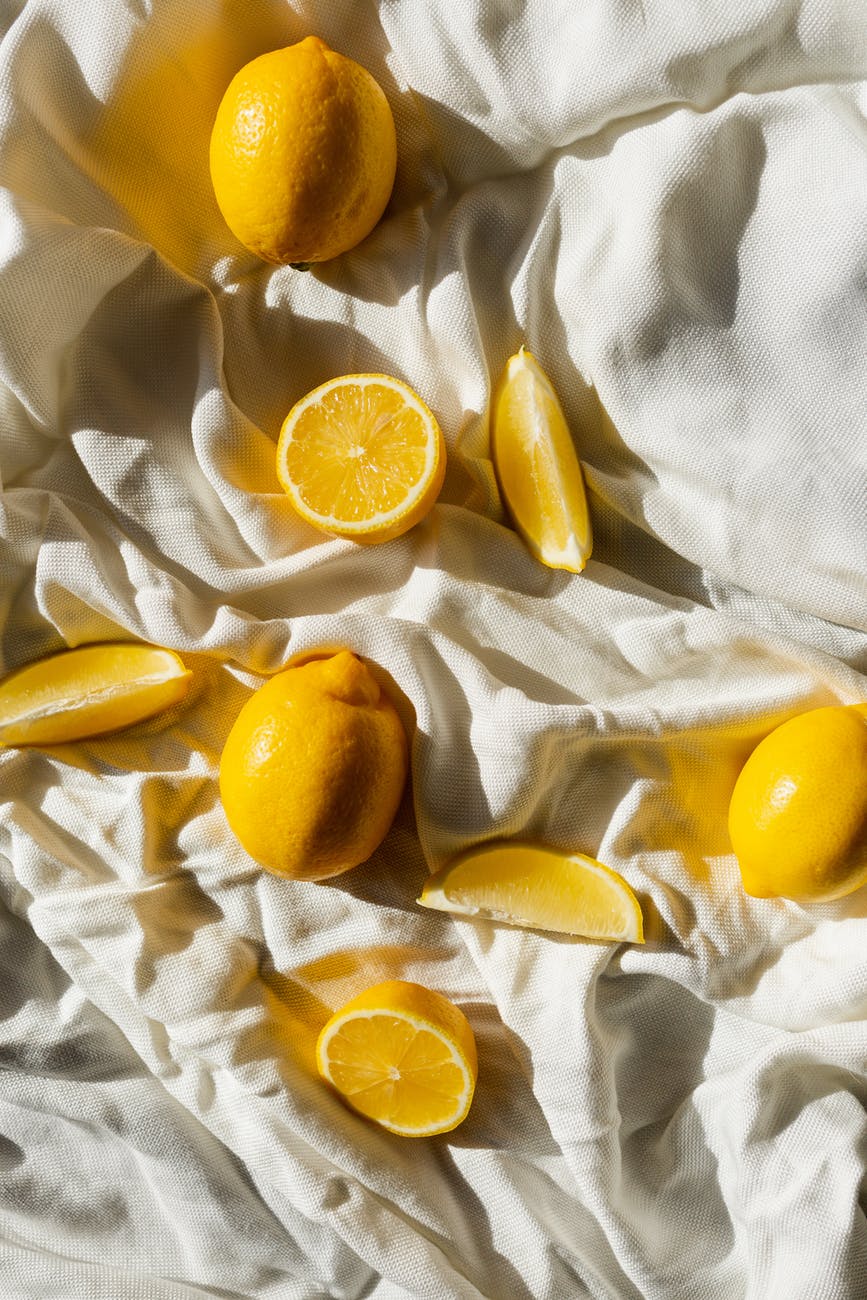 fresh lemons on crumpled bed sheet at home